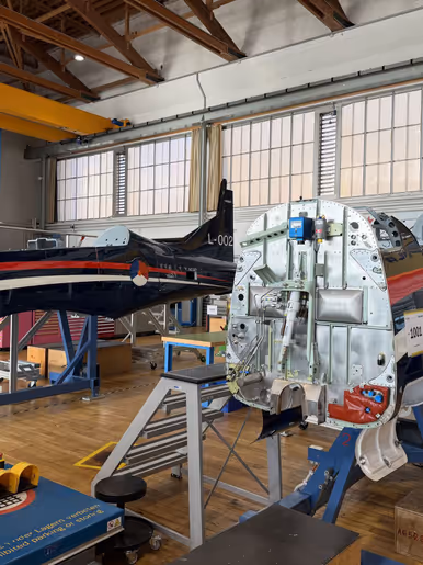 Foto van een lesvliegtuig in aanbouw in een fabriek. 