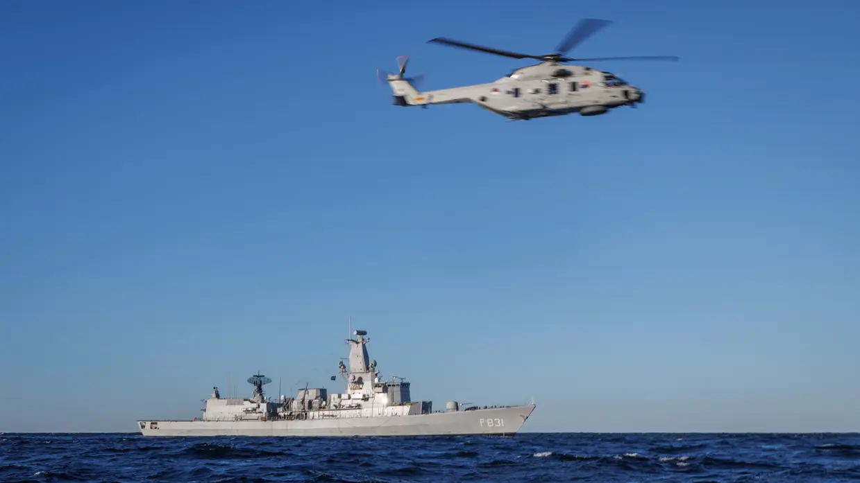 Een NH90-helikopter vliegt boven een schip. 