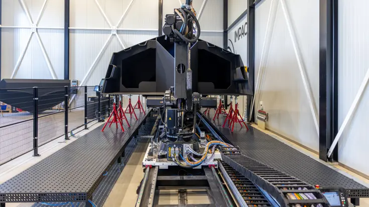 De romp van een 3D-geprinte boot op een werkbank.
