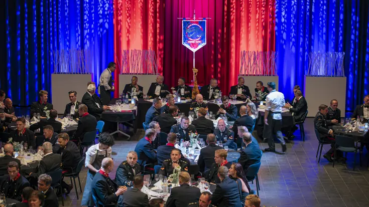 Een zaal met meerdere tafel waaraan mariniers met elkaar in gesprek zijn.