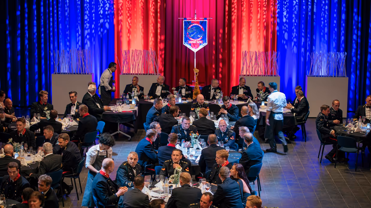 Een zaal met meerdere tafel waaraan mariniers met elkaar in gesprek zijn.