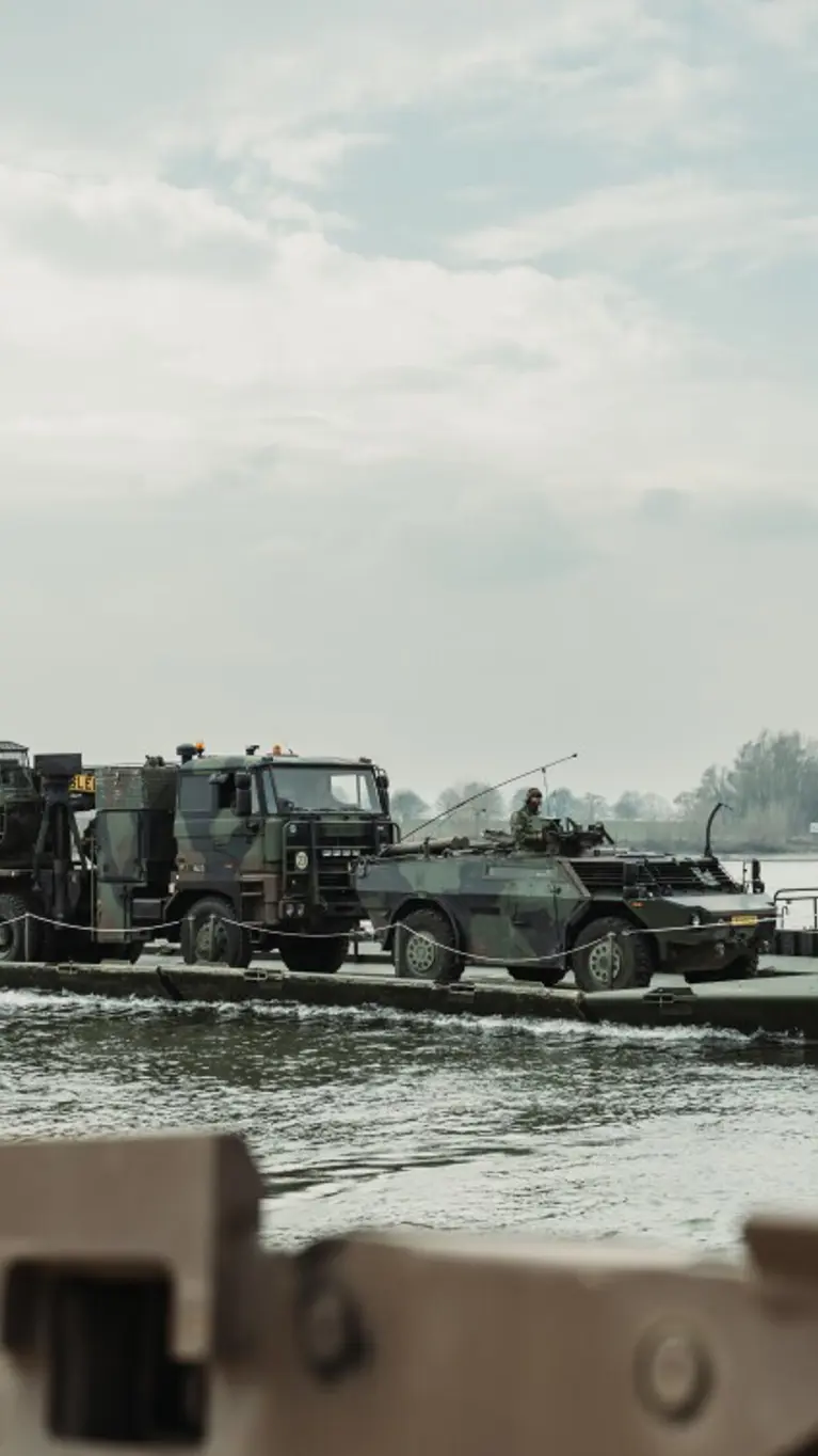 Militair materieel op een mobiel brugsysteem.