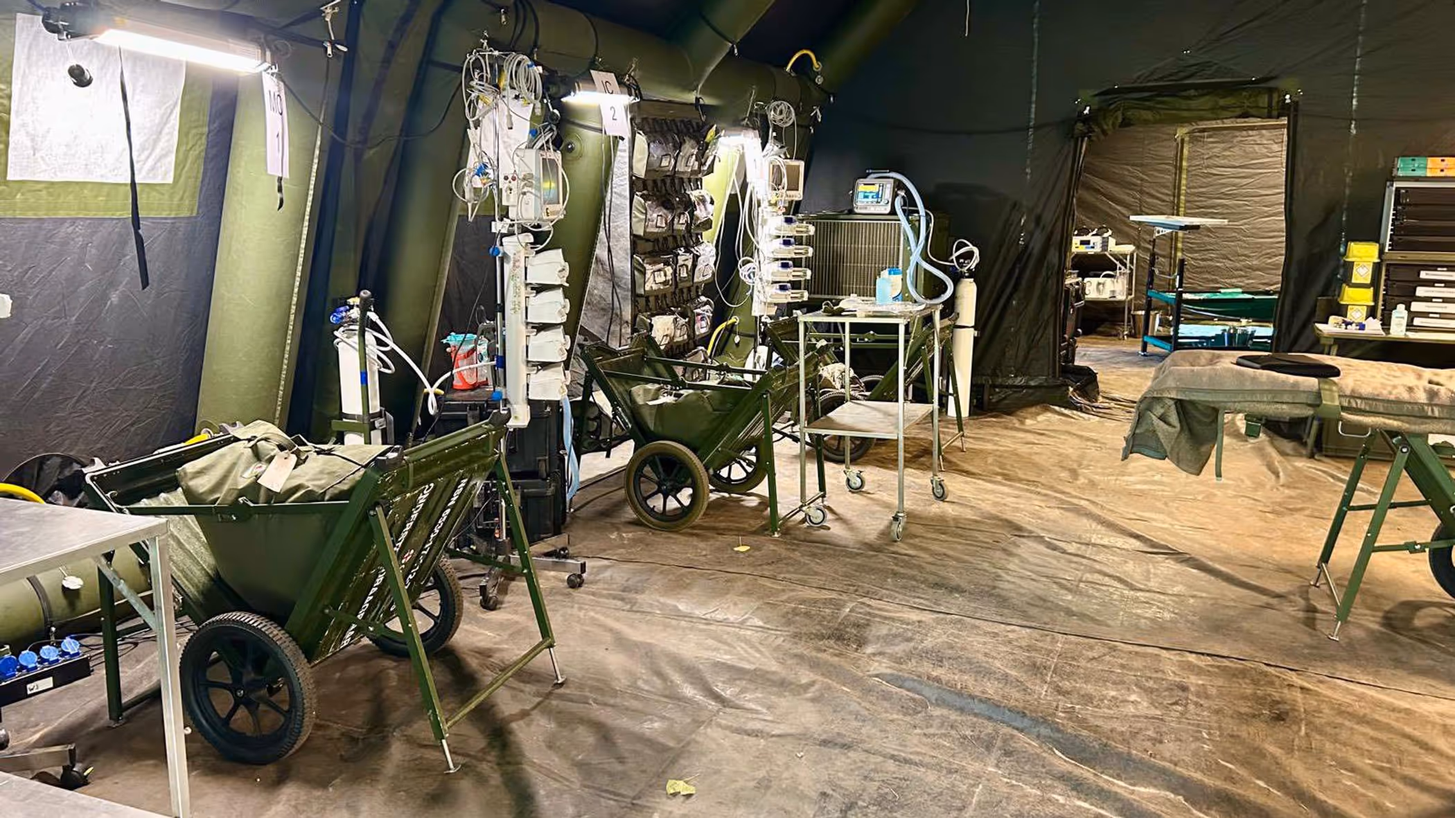 Alttekst: Een medische ruimte in een tent vol apparatuur en bedden. 