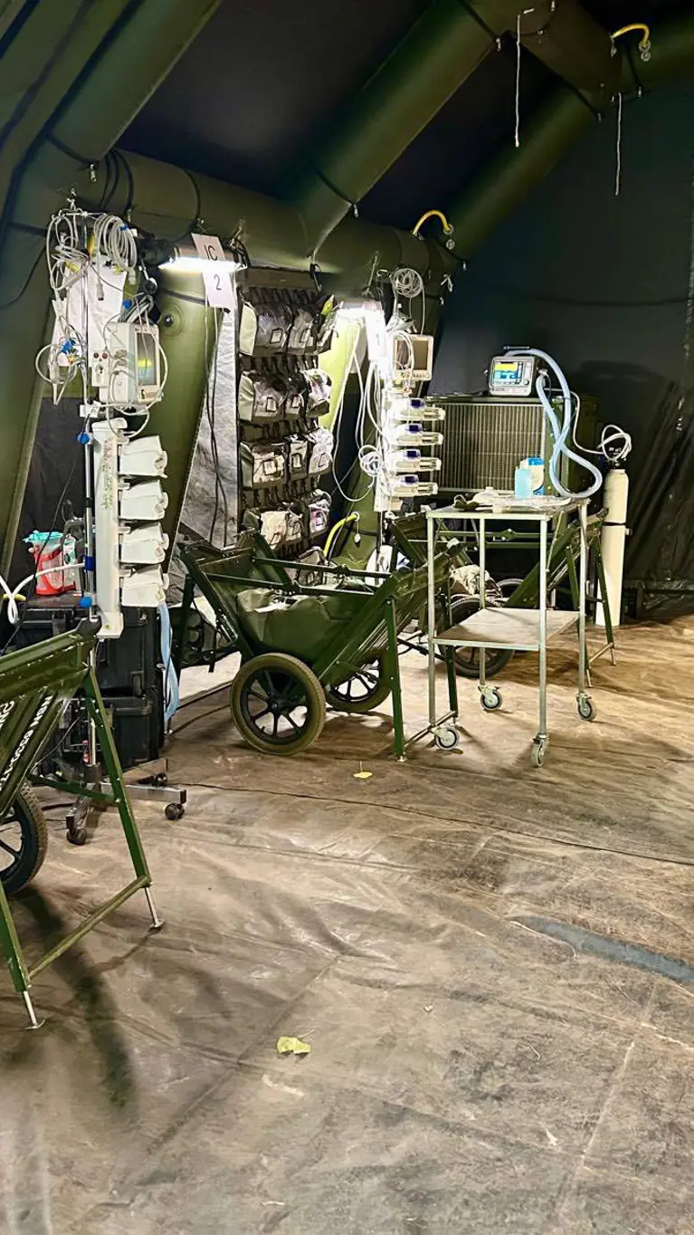 Alttekst: Een medische ruimte in een tent vol apparatuur en bedden. 
