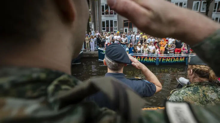 Militairen brengen de eregroet aan het publiek op de kant. 