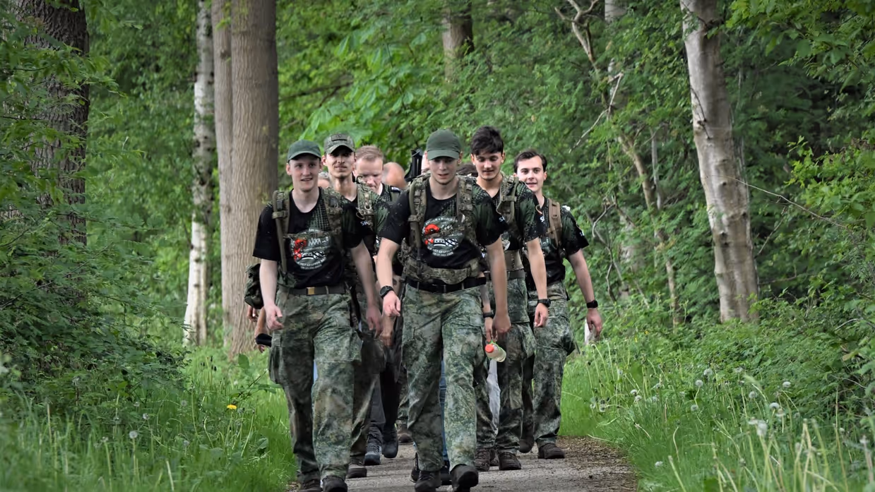 De militairen lopen door een bosgebied.