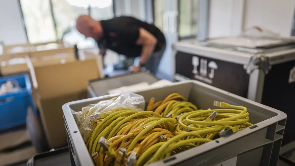 Een bak vol netwerkkabels staat klaar tijdens de ICT-opbouw voor Falcon Leap.