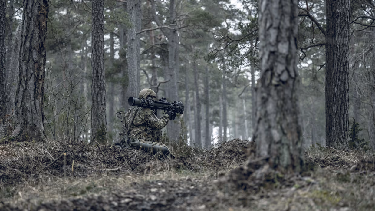 Militairen in het bos met een wapen op de schouder.