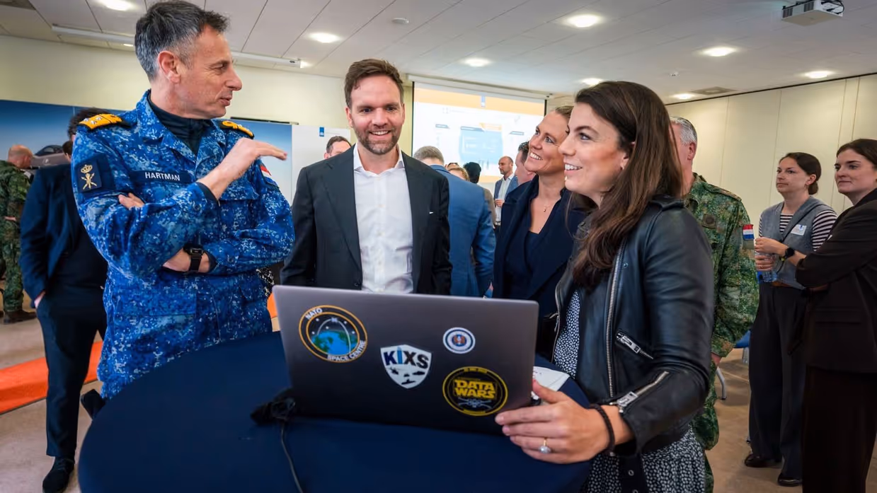 Viceadmiraal Jan Willem Hartman en Sofie laten de vernieuwde DefGPT zien aan staatssecretaris van Defensie Derk Boswijk.