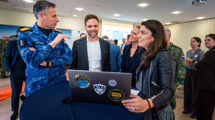 Viceadmiraal Jan Willem Hartman en Sofie laten de vernieuwde DefGPT zien aan staatssecretaris van Defensie Derk Boswijk.