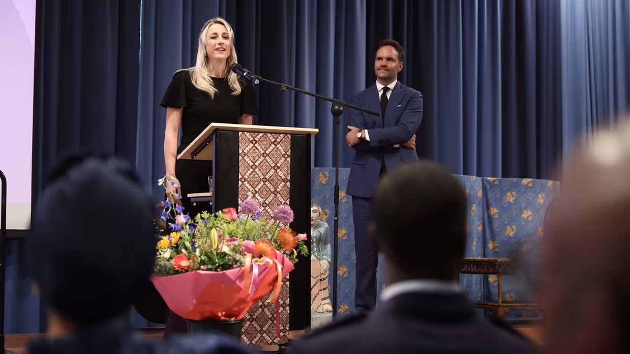 Een lachende Amber spreekt door de microfoon.