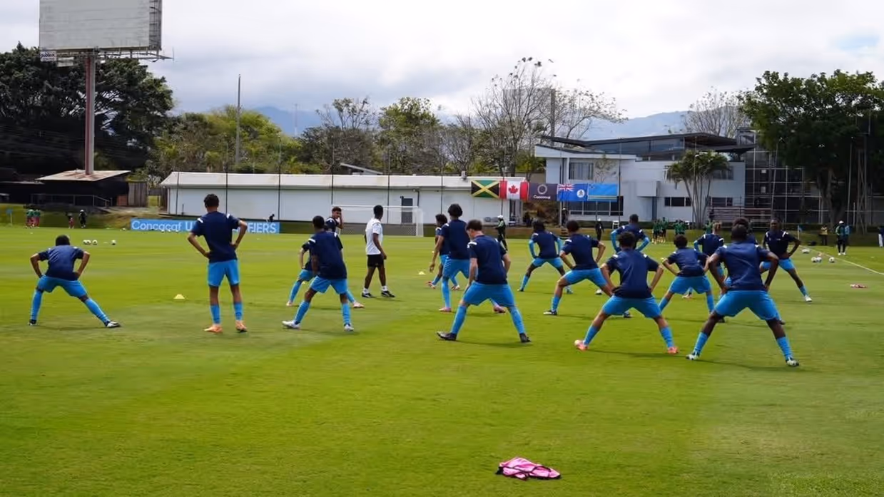 Voetballers doen oefeningen op een trainingsveld. 