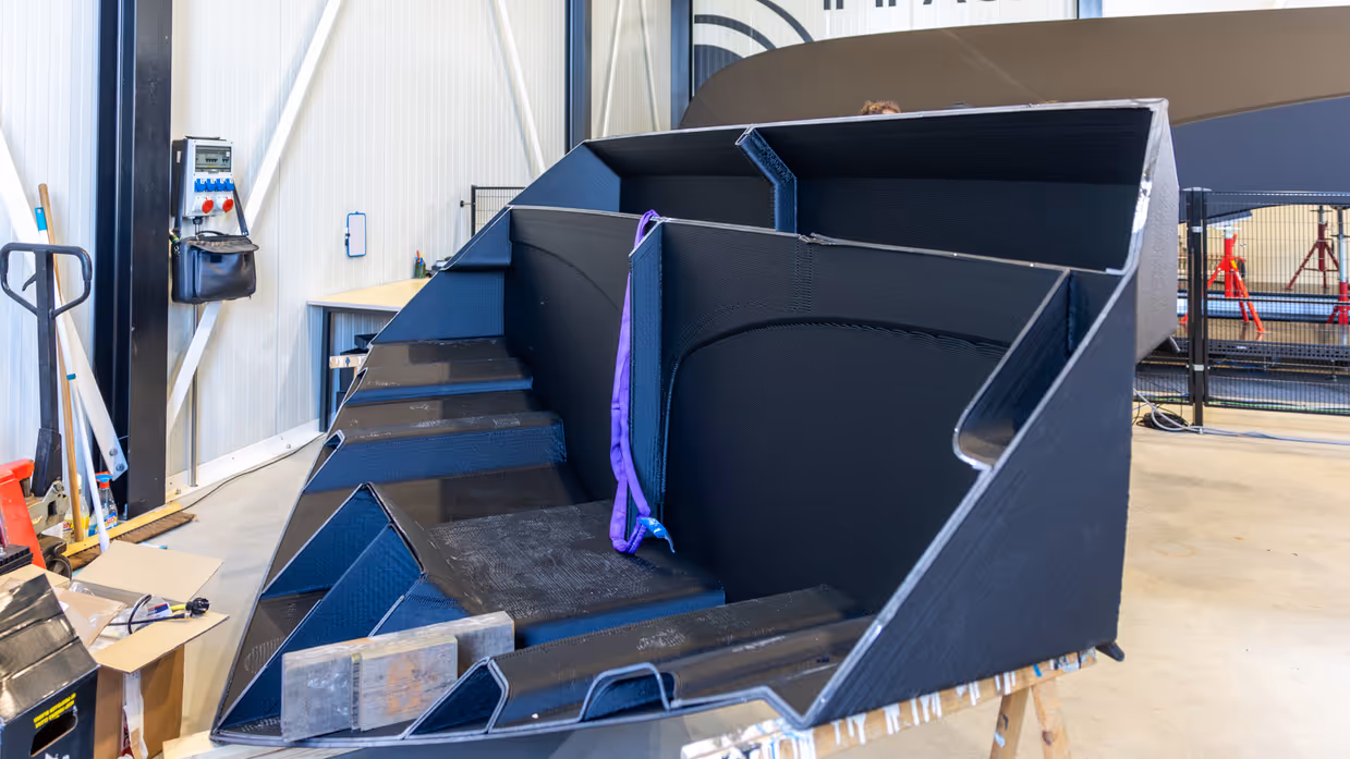 De neus van een 3D-geprinte boot met daarachter de romp van het vaartuig.