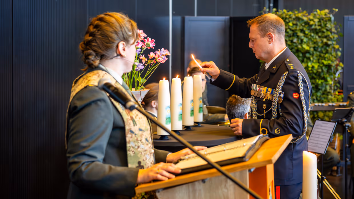 Onderdeelsadjudant Johan Nagel steekt een kaars aan. Dit is de derde in een rij van vier. De laatste brandt nog niet. 
