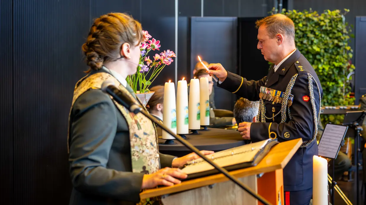 Onderdeelsadjudant Johan Nagel steekt een kaars aan. Dit is de derde in een rij van vier. De laatste brandt nog niet. 