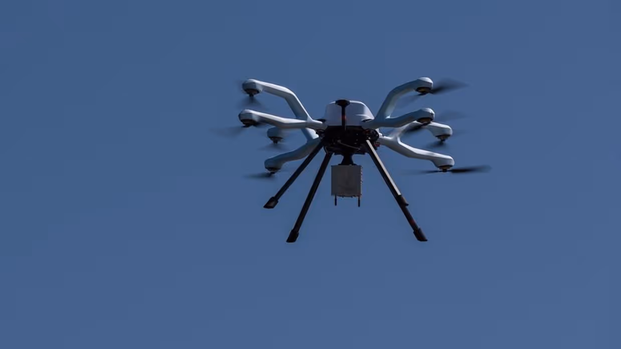 Een oranje onderwaterdrone half ondergedoken in het water. Op de andere foto een vliegende drone met meerdere rotoren.&nbsp;