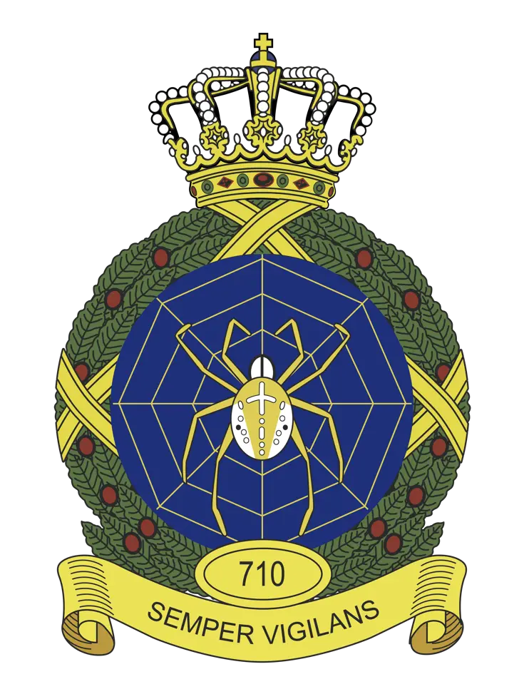 Kleurenfoto van een embleem met een spin in een web en een lauwerkrans eromheen.