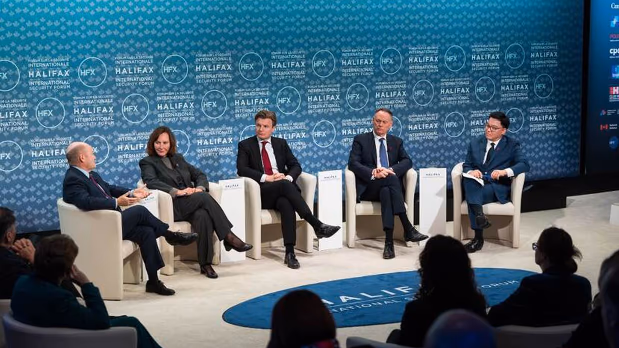 Minister Brekelmans zit in een paneldiscussie met 4 anderen. Op de blauwe achtergrond staat talloze keren: Halifax.