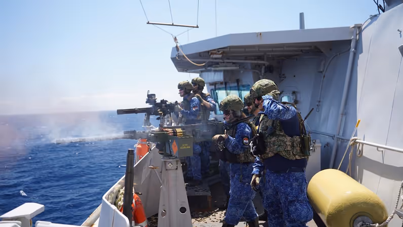 Bemanningsleden vuren met miniguns op een van de dekken van het schip.
