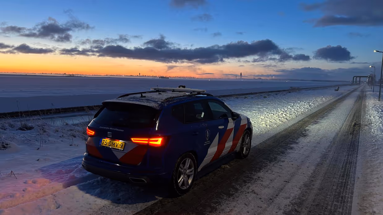 Voertuig van de Marechaussee voor besneeuwd Schiphol.