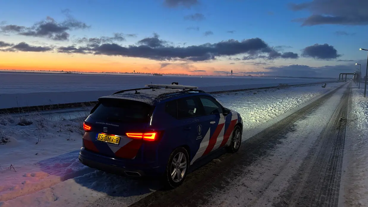Voertuig van de Marechaussee voor besneeuwd Schiphol.