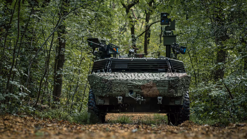 Een militair voertuig midden in het bos. 