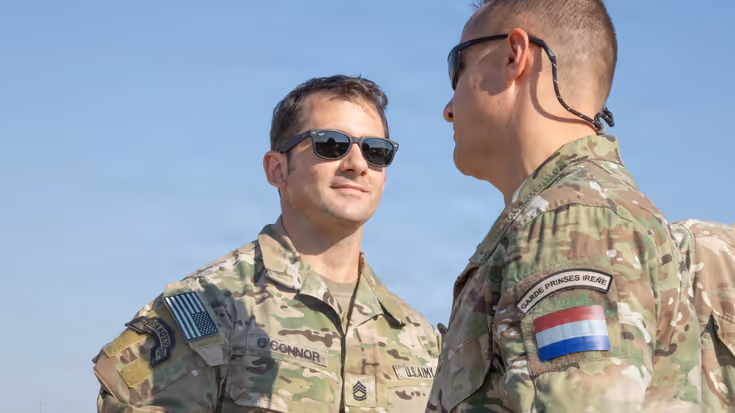 Amerikaanse en Nederlandse militair schudden elkaar de hand.