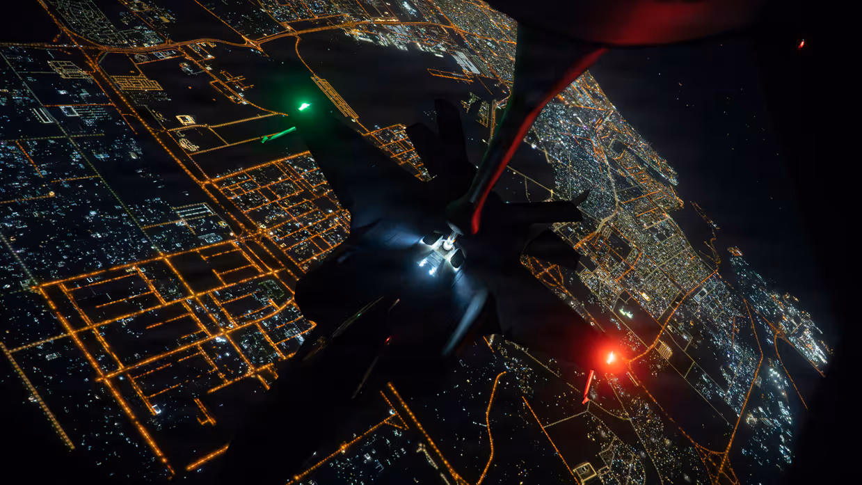 Een F-35 wordt in de lucht bijgetankt hangend aan een KC-135 Stratotanker tegen een donkere lucht.