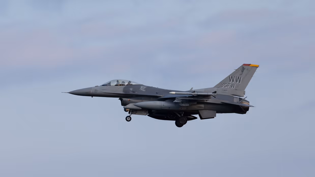 Een F-16 in de landing onder een blauwe lucht. 