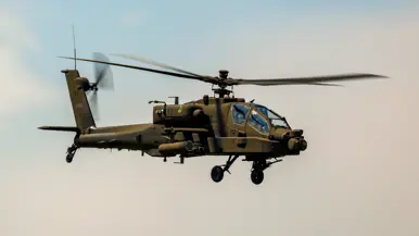 Een militaire helikopter van de zijkant gezien onder een blauwe lucht.