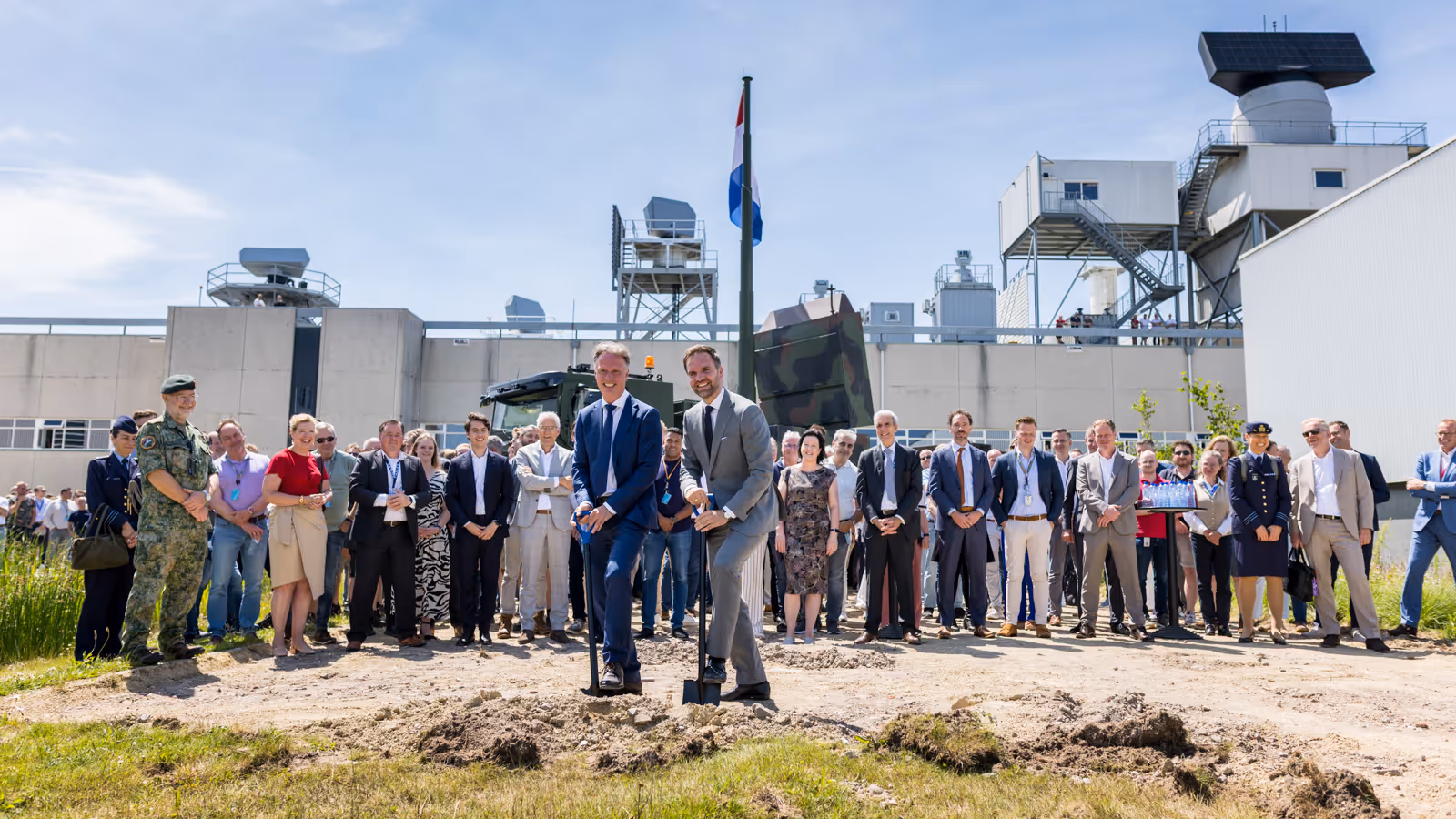 Twee mannen steken een schop in de grond. 