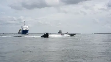 2 kleine vaartuigen en 2 grote schepen varen in formatie.
