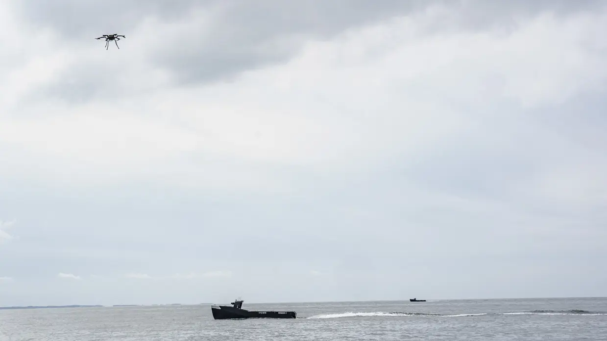 een drone vliegt boven kleine onbemande boot