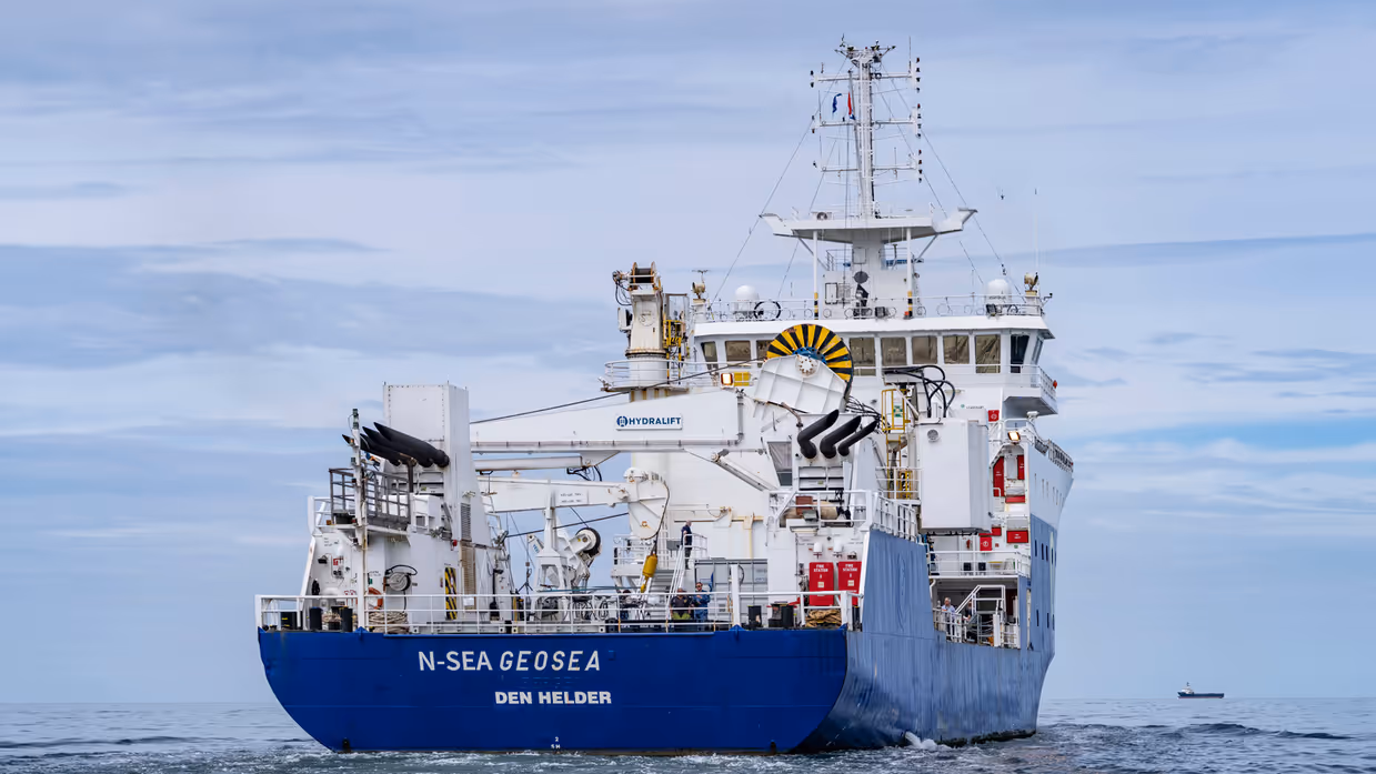 Achterkant van groot schip dat op zee vaart.