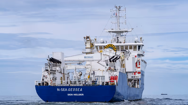 Achterkant van groot schip dat op zee vaart.