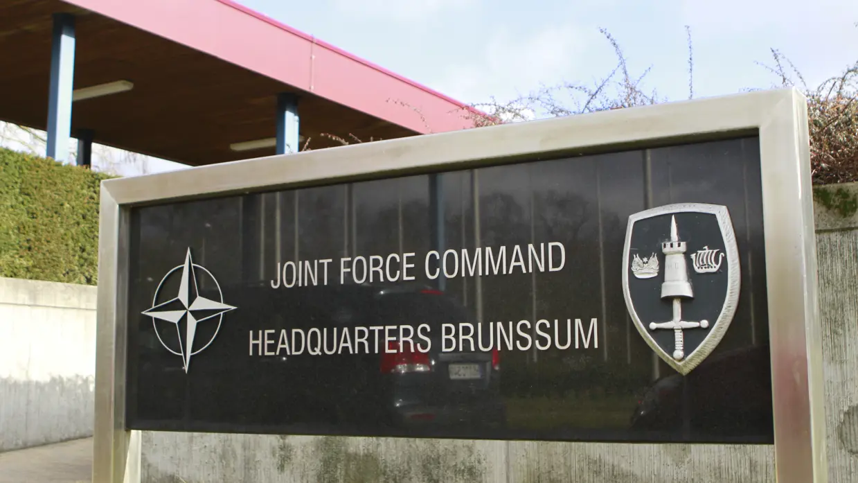 Een toegangsbord waarop de naam van het Joint Force Command Brunssum te lezen is. 