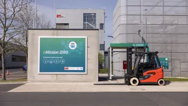 MedRes_yikpdzq_Opening_Laadstation_KHK: close-up van een oplaadkabel in een auto.    _s_l9372: een vorkheftruck staat naast een laadstation voor waterstof. 
