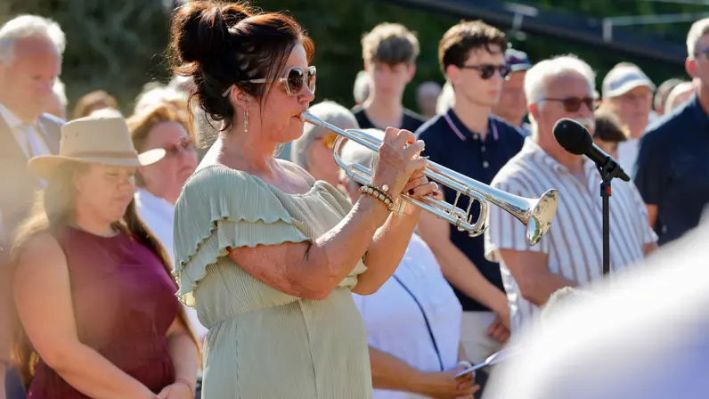 een vrouw in groene jurk speelt op een muziekinstrument.