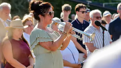 Nathalie de Cloe, een van de overlevenden, speelt op een trompet. Achter haar staat publiek.