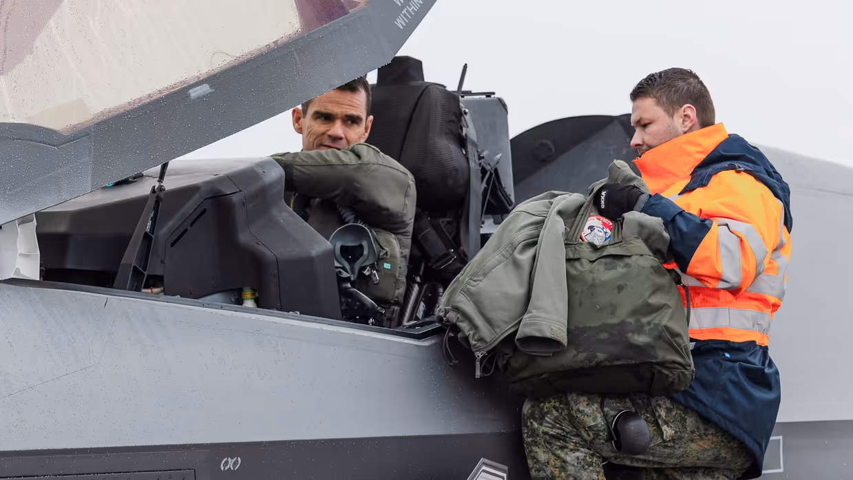  Een man zit in de cockpit van een F-35, een man aan de zijkant van het vliegtuig spreekt tegen hem.