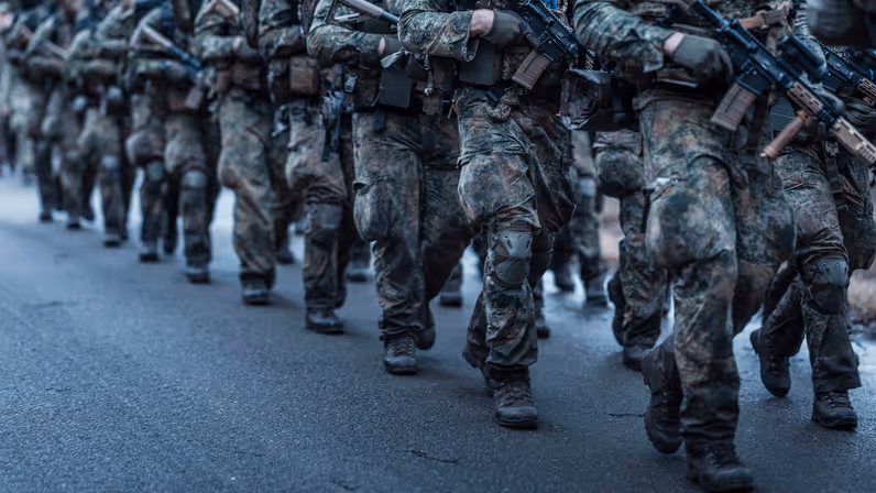 Marcherende militairen, alleen hun benen zijn zichtbaar.