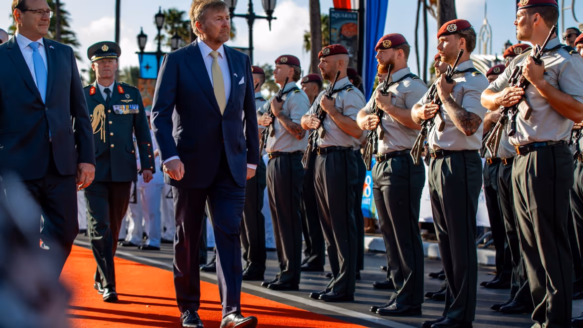 De koning loopt langs opgestelde militairen