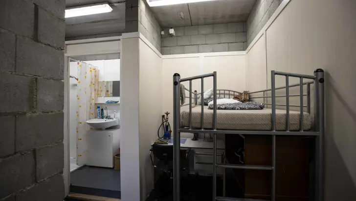 Hoogslaper met daaronder een bureau en links een badkamer.