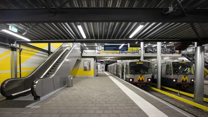 Metroperron met roltrap en 2 metro's.