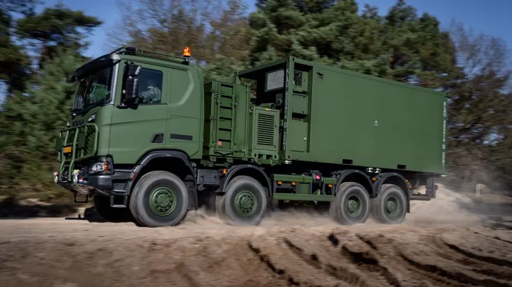 De 8-wielaangedreven (4-assig) high operational rijdt door de modder in het bos.