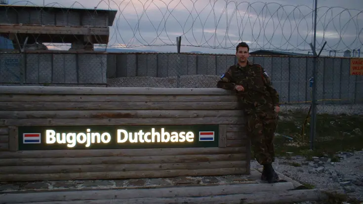 Een jonge Marcel Pelster poseert bij het bord bij de ingang van het kamp in Bosnië. Foto: uit privé-archief