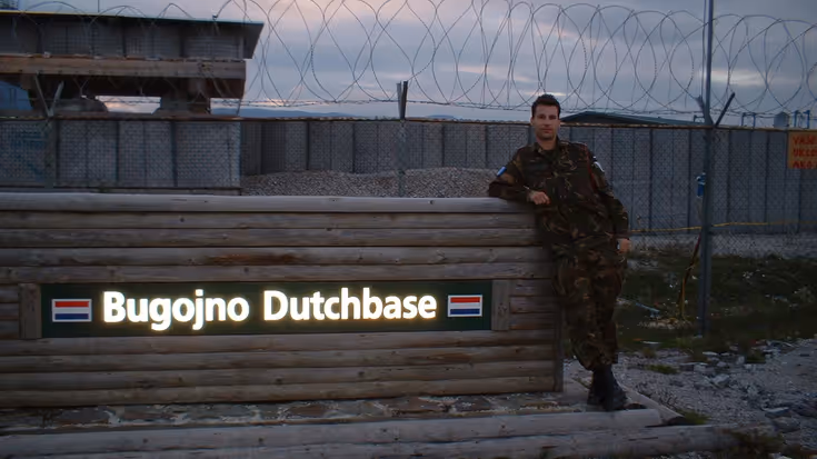 Een jonge Marcel Pelster poseert bij het bord bij de ingang van het kamp in Bosnië. Foto: uit privé-archief