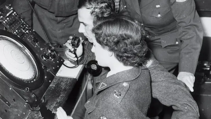 Vrouwelijk en mannelijke militairen kijken op een radar.
