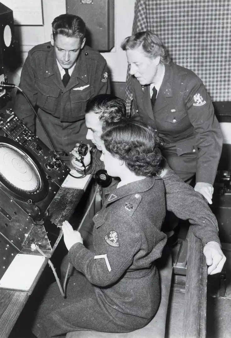 Vrouwelijk en mannelijke militairen kijken op een radar.