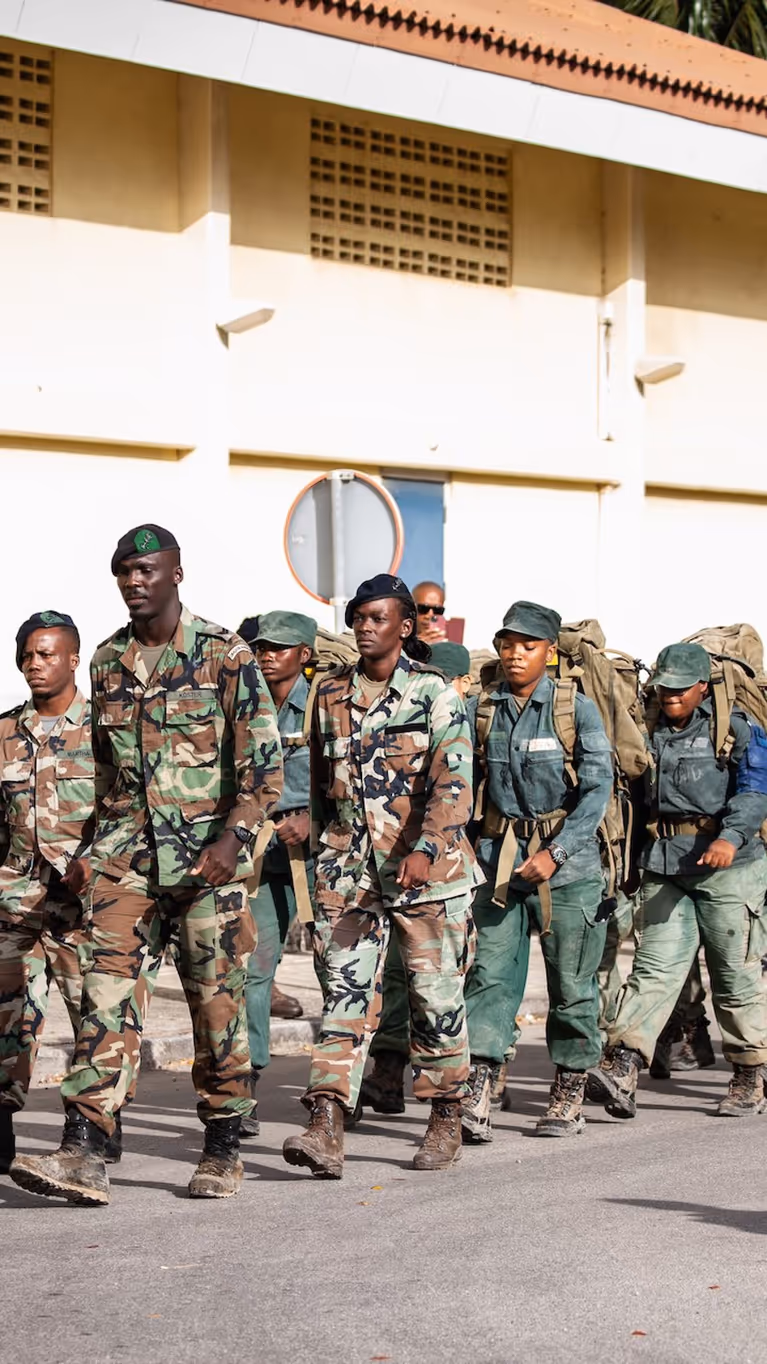 Curaçaose militairen marcheren achter elkaar aan.
